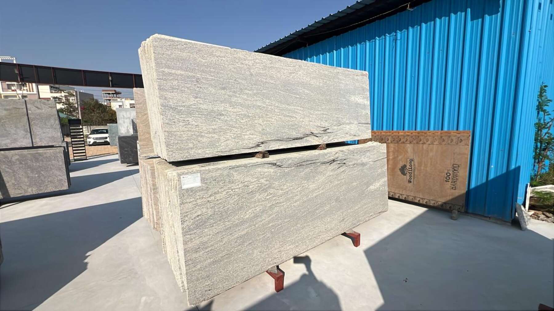 Stacked stone slabs on pallets in the open yard under daylight